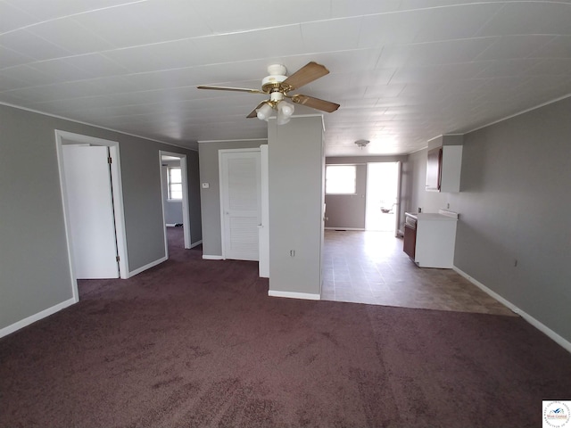 206 N Ohio St, Chilhowee, MO 64733 - unfurnished living room featuring baseboards, dark colored carpet, a healthy amount of sunlight, and ceiling fan