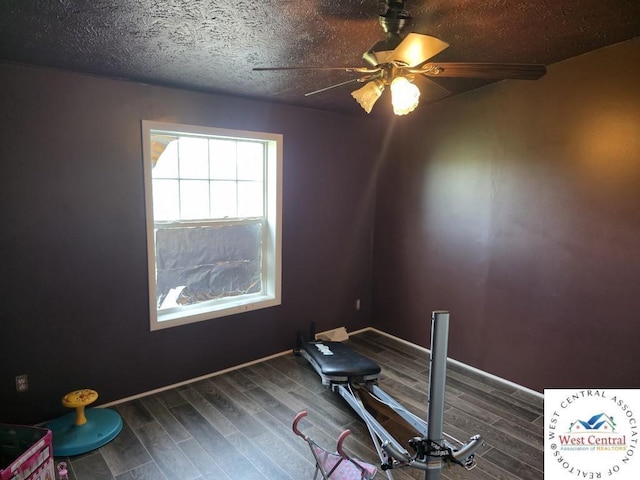 workout room featuring baseboards, wood finished floors, and a ceiling fan