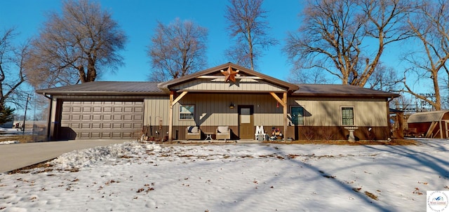 ranch-style home with metal roof, concrete driveway, and an attached garage