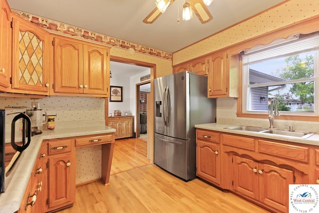 904 Leone Ave, Sedalia, MO 65301 - kitchen featuring light wood-style flooring, wallpapered walls, a sink, stainless steel fridge with ice dispenser, and light countertops