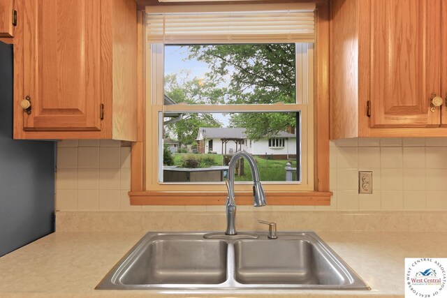 904 Leone Ave, Sedalia, MO 65301 - kitchen featuring a sink, backsplash, and light countertops
