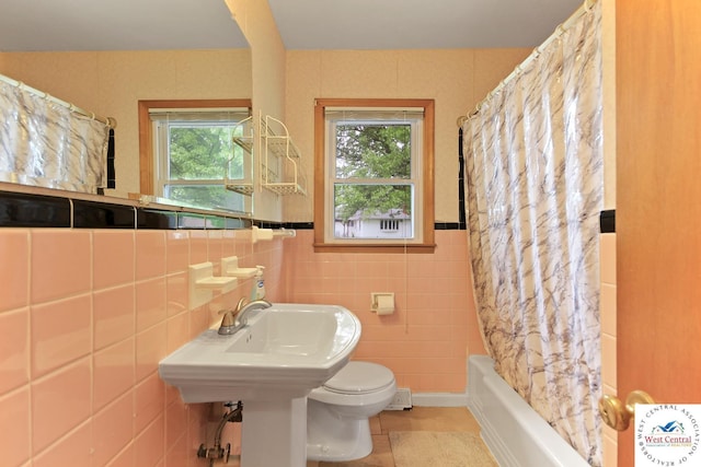 904 Leone Ave, Sedalia, MO 65301 - full bath with shower / tub combo with curtain, tile patterned flooring, tile walls, and toilet