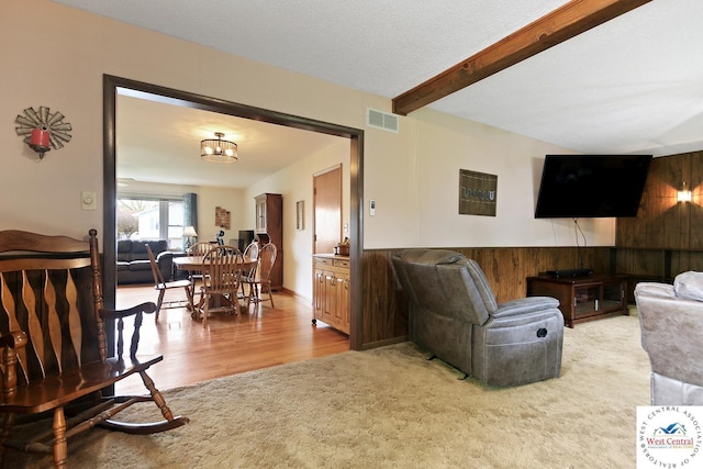 904 Leone Ave, Sedalia, MO 65301 - living area with visible vents, wooden walls, a wainscoted wall, wood finished floors, and beamed ceiling