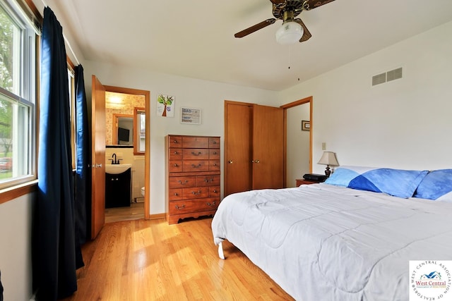 904 Leone Ave, Sedalia, MO 65301 - bedroom with multiple windows, light wood-style floors, ensuite bath, and visible vents