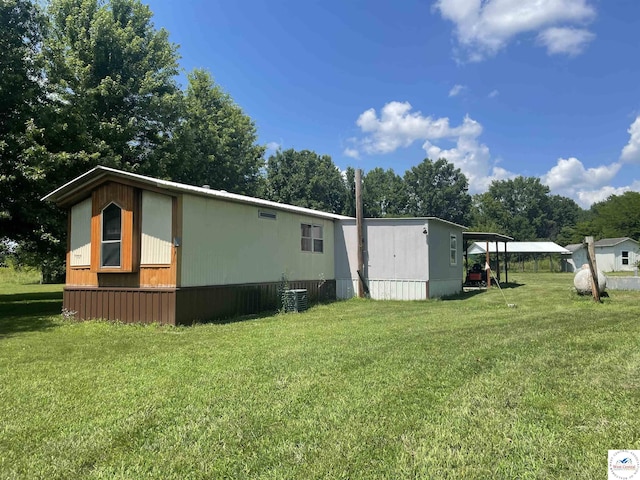17254 Walnut Rd, Warsaw, MO 65355 - view of side of home featuring a yard, a carport, and view of wooded area