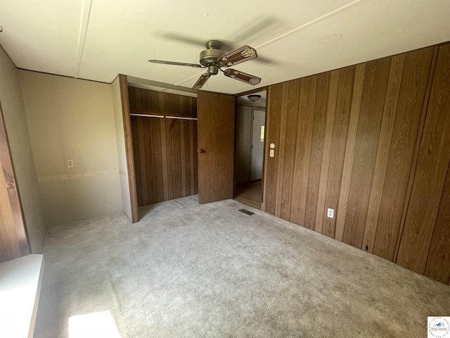 17254 Walnut Rd, Warsaw, MO 65355 - unfurnished bedroom with light carpet, wooden walls, a closet, and ceiling fan