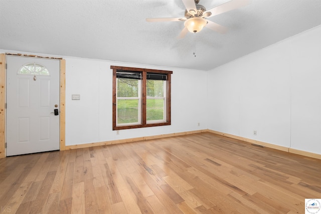interior space with light wood-style floors, baseboards, ceiling fan, and visible vents