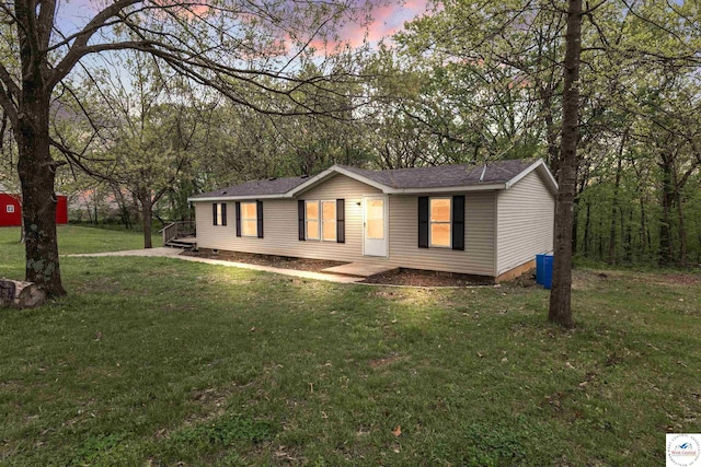 manufactured / mobile home with a shingled roof, crawl space, and a front yard