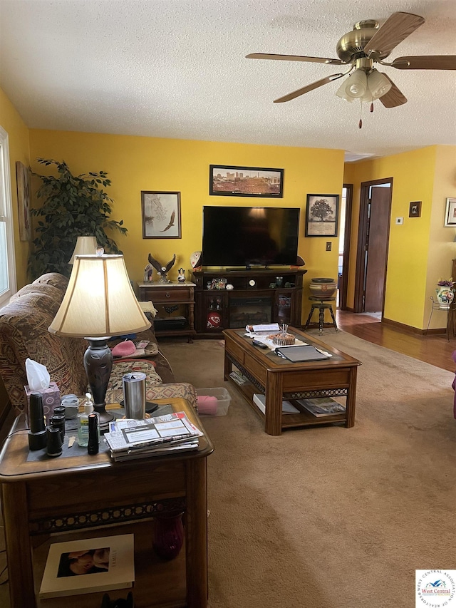 carpeted living area featuring a textured ceiling and ceiling fan
