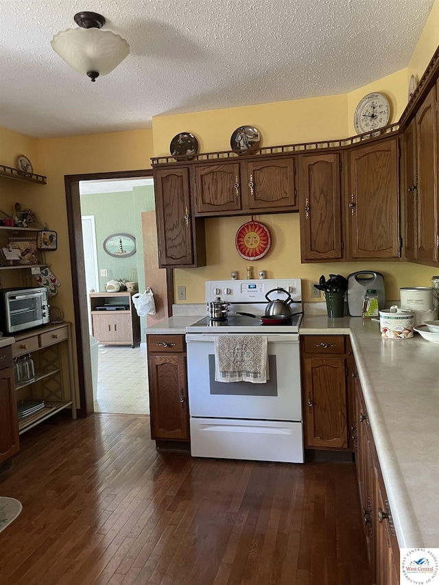 kitchen featuring a textured ceiling, light countertops, white electric range, and dark wood-style floors
