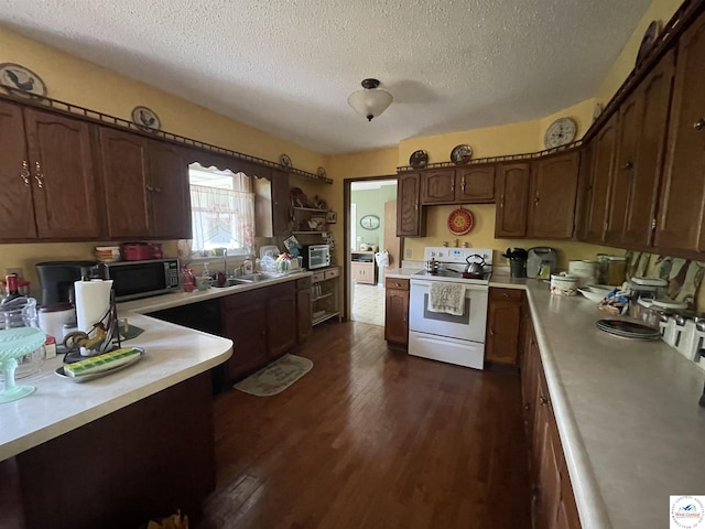 kitchen featuring a textured ceiling, a sink, white range with electric cooktop, light countertops, and dark wood-style floors