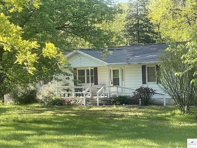 ranch-style home featuring a front lawn, roof with shingles, and covered porch
