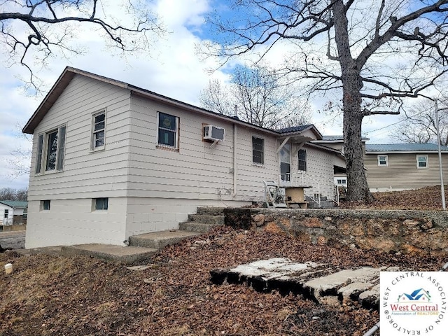 view of home's exterior with an AC wall unit