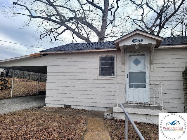 doorway to property featuring crawl space and roof with shingles