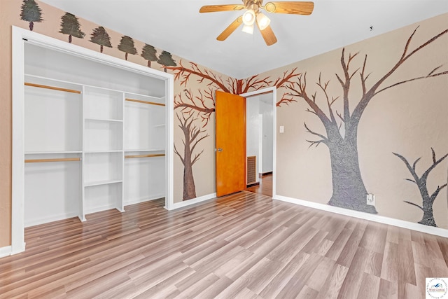 unfurnished bedroom featuring baseboards, wallpapered walls, and wood finished floors