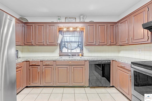kitchen featuring light stone countertops, a sink, stainless steel appliances, decorative backsplash, and light tile patterned floors