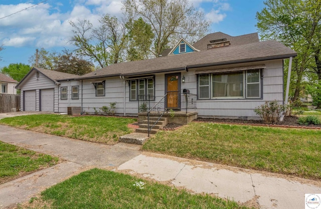 view of front of home featuring roof with shingles, a front yard, and a garage