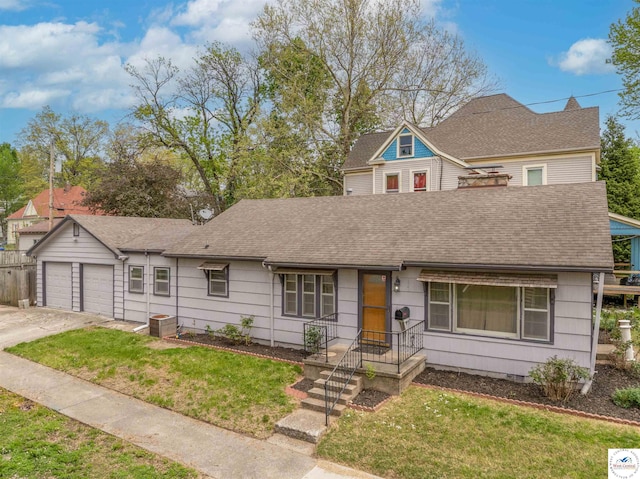view of front of house featuring a shingled roof, a front lawn, and a detached garage