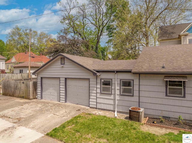 garage with fence and central AC unit
