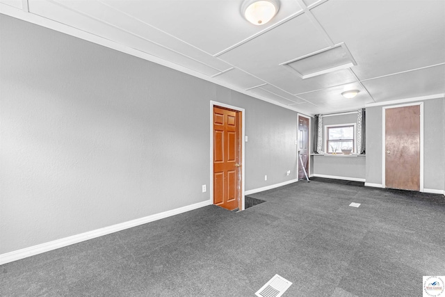 spare room with baseboards, attic access, dark carpet, and visible vents