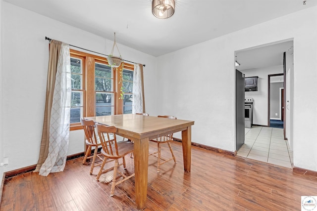 dining room featuring baseboards and light wood-style flooring