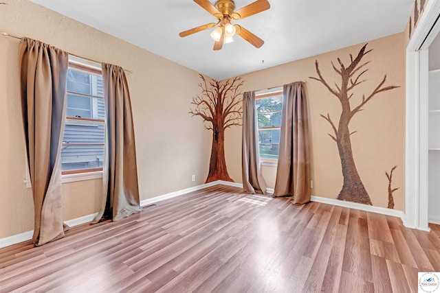 unfurnished room featuring baseboards, ceiling fan, and light wood-type flooring