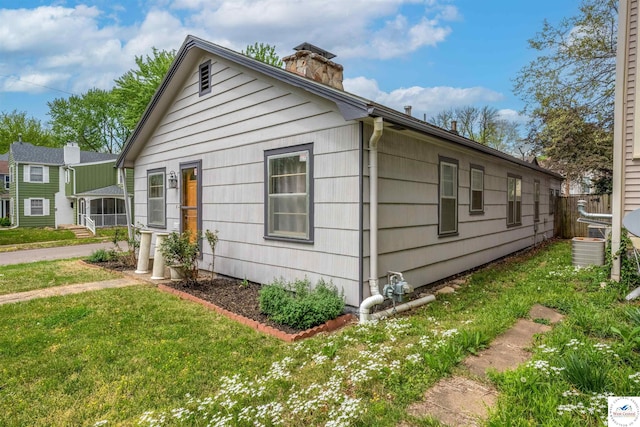 exterior space featuring a front lawn and a chimney