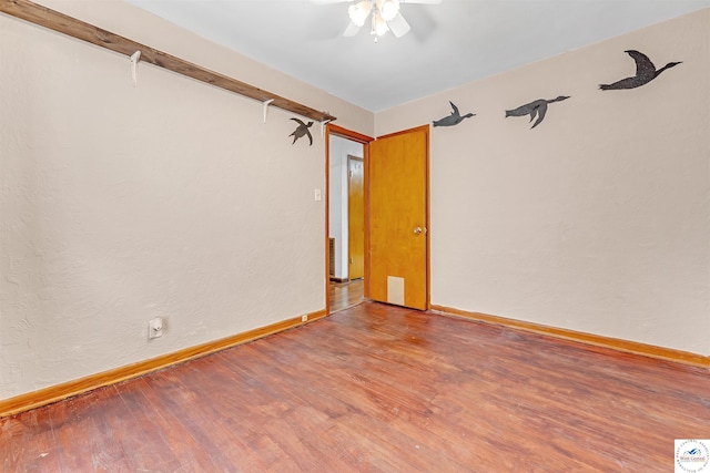 unfurnished room featuring baseboards, a ceiling fan, and wood finished floors