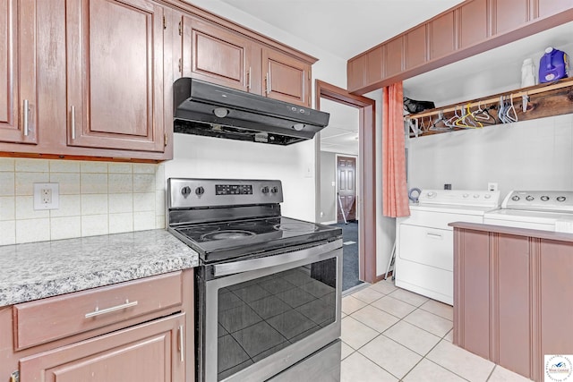 kitchen with washer and dryer, light tile patterned flooring, light countertops, stainless steel electric range, and under cabinet range hood