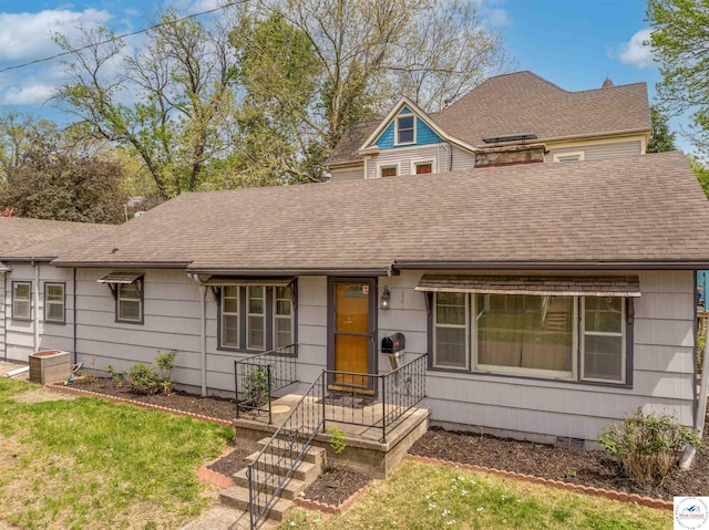 view of front of property with crawl space, a shingled roof, and a front lawn