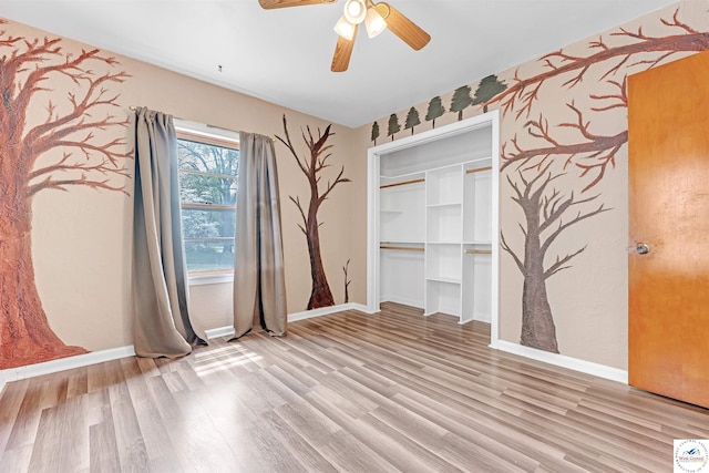 empty room with a ceiling fan, baseboards, and light wood finished floors