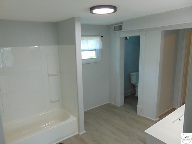 311 N Water St, Clinton, MO 64735 - full bathroom with wood finished floors, visible vents, vanity, and shower / bathtub combination
