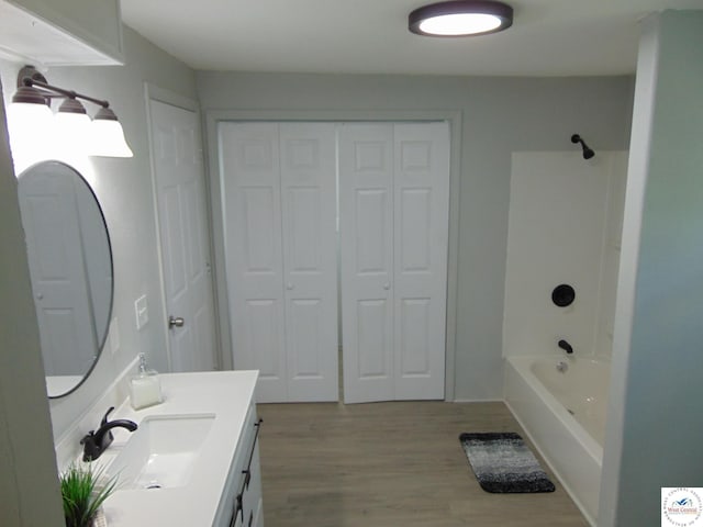 311 N Water St, Clinton, MO 64735 - full bath with wood finished floors, shower / washtub combination, vanity, and a closet