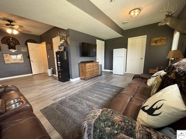 225 Crescent Dr, Lincoln, MO 65338 - living room featuring ceiling fan, light wood-style flooring, a textured ceiling, and lofted ceiling
