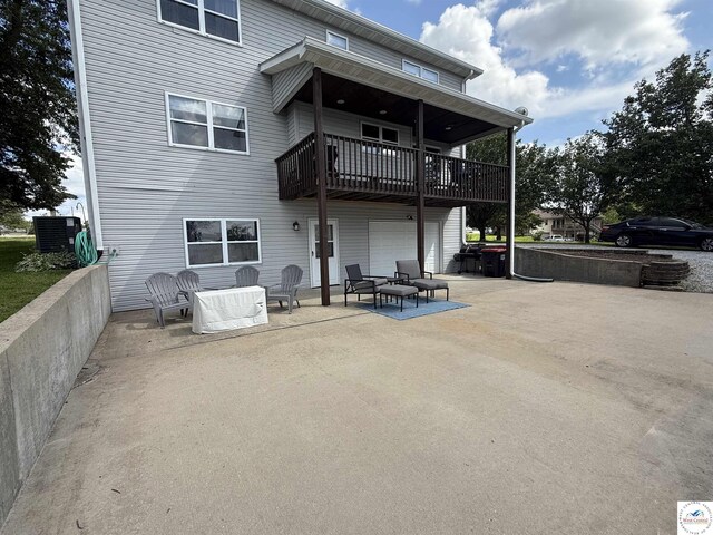 225 Crescent Dr, Lincoln, MO 65338 - back of house featuring a garage, concrete driveway, and a patio