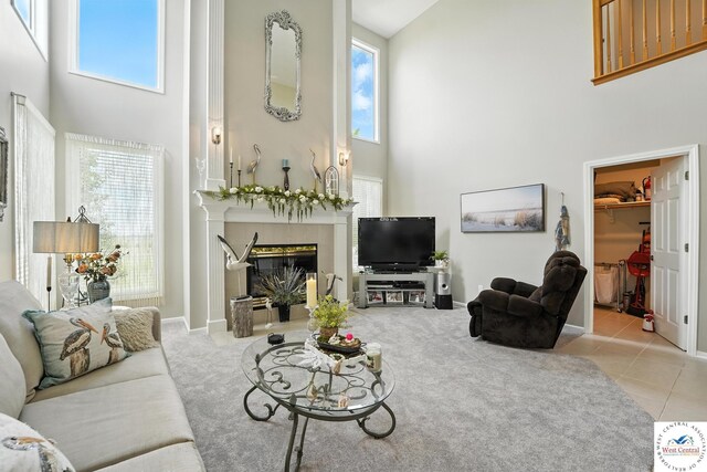 414 S Borgman Rd, Buckner, MO 64016 - living room with a high ceiling, a glass covered fireplace, healthy amount of natural light, and carpet flooring