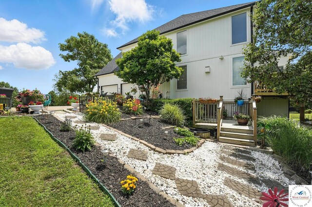 414 S Borgman Rd, Buckner, MO 64016 - rear view of house featuring a wooden deck, roof with shingles, and a garage