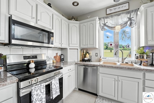 414 S Borgman Rd, Buckner, MO 64016 - kitchen featuring stainless steel appliances, decorative backsplash, white cabinetry, light tile patterned floors, and hanging light fixtures