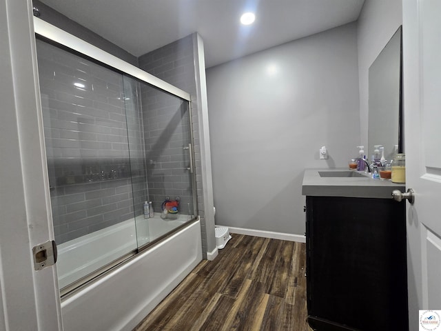 1824 S Grand Ave, Sedalia, MO 65301 - bathroom with wood finished floors, vanity, bath / shower combo with glass door, and recessed lighting