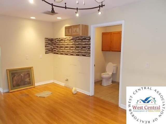 washroom featuring baseboards, an inviting chandelier, and light wood-type flooring