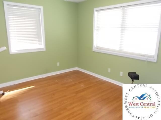 spare room featuring light wood-style flooring and baseboards