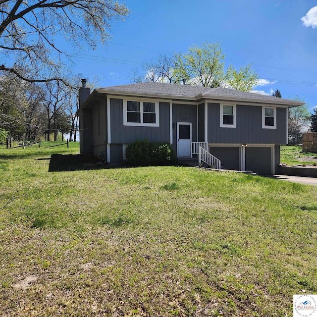2206 N Swisher Dr, Clinton, MO 64735 - bi-level home with a front lawn, driveway, a garage, and a chimney