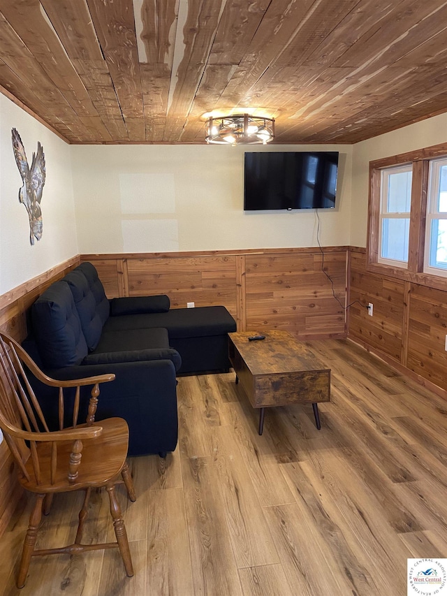 living area featuring wooden ceiling, wood finished floors, a wainscoted wall, and wood walls