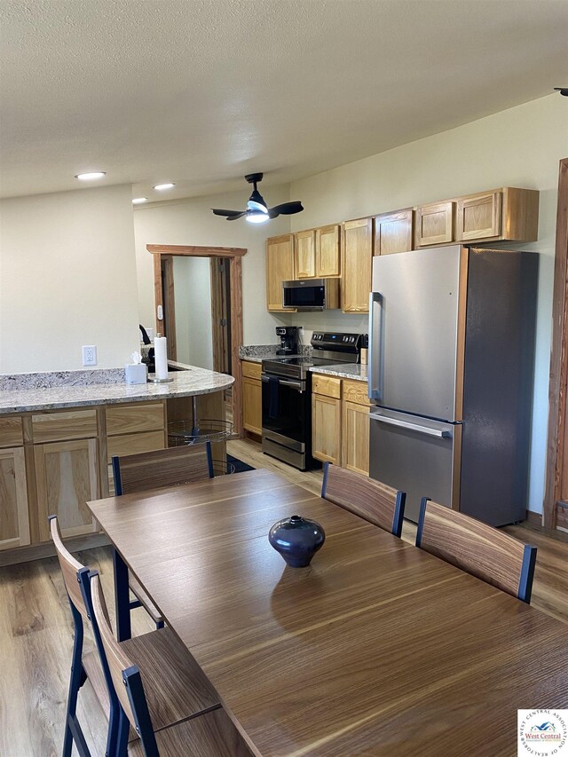 dining area featuring light wood-type flooring, a ceiling fan, and recessed lighting