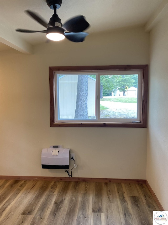 empty room with wood finished floors, ceiling fan, and baseboards