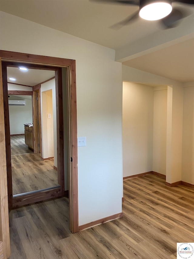 unfurnished room featuring wood finished floors, ceiling fan, and baseboards