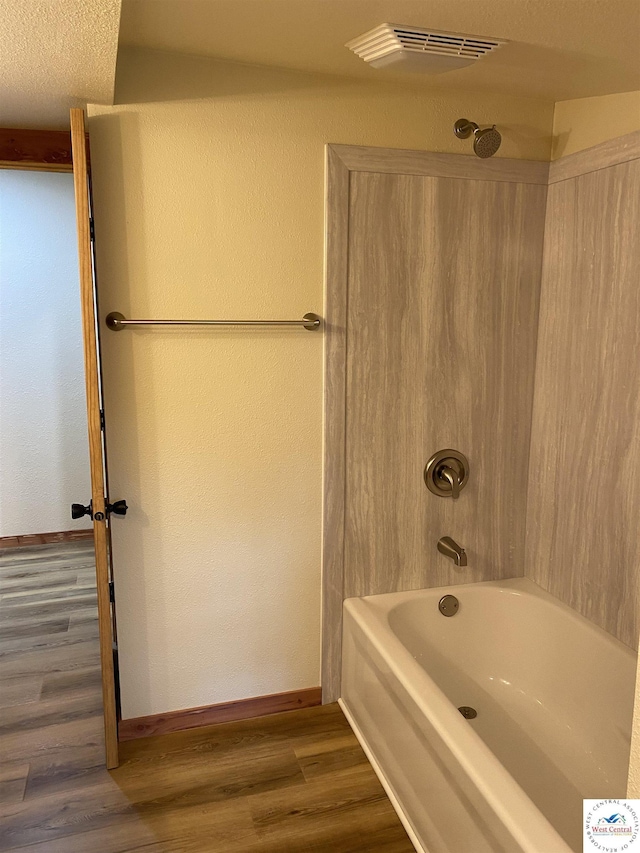 full bath with visible vents, wood finished floors,  shower combination, and baseboards