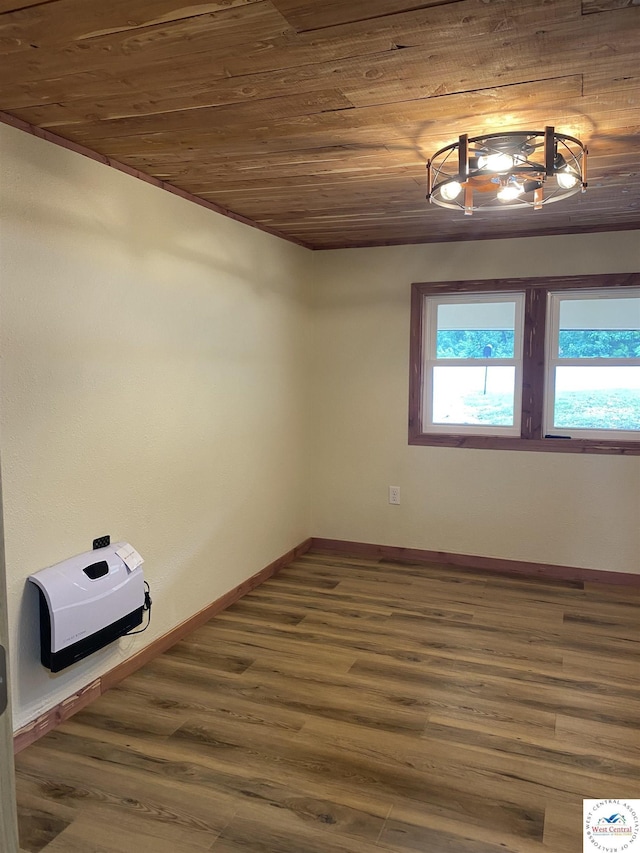 spare room featuring wood ceiling, wood finished floors, and baseboards