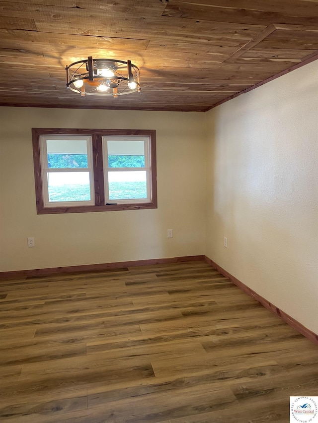 spare room featuring baseboards, wood finished floors, and wood ceiling