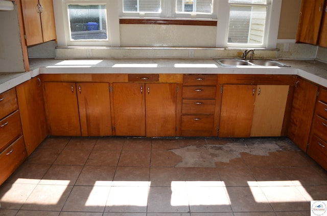 1305 E 14th St, Sedalia, MO 65301 - kitchen with a sink, light countertops, and brown cabinets